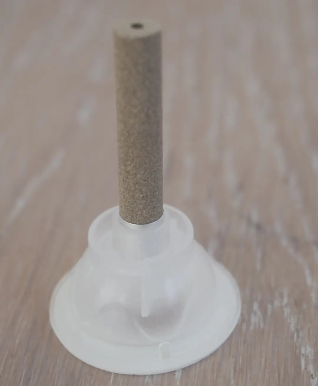 An assembled self-adhesive moxa unit — stick seated in its base